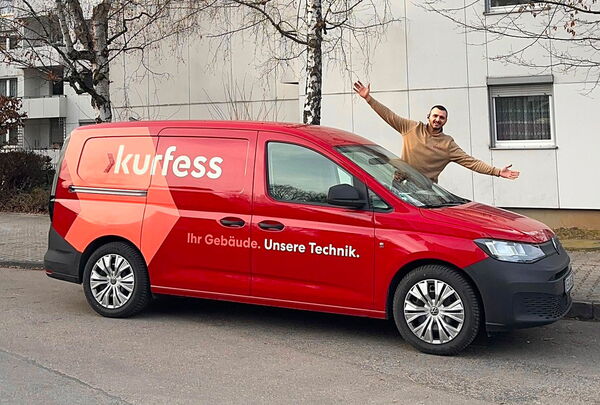Rotes Kurfess Servicefahrzeug mit auffälliger Firmenbeschriftung vor einem Gebäude